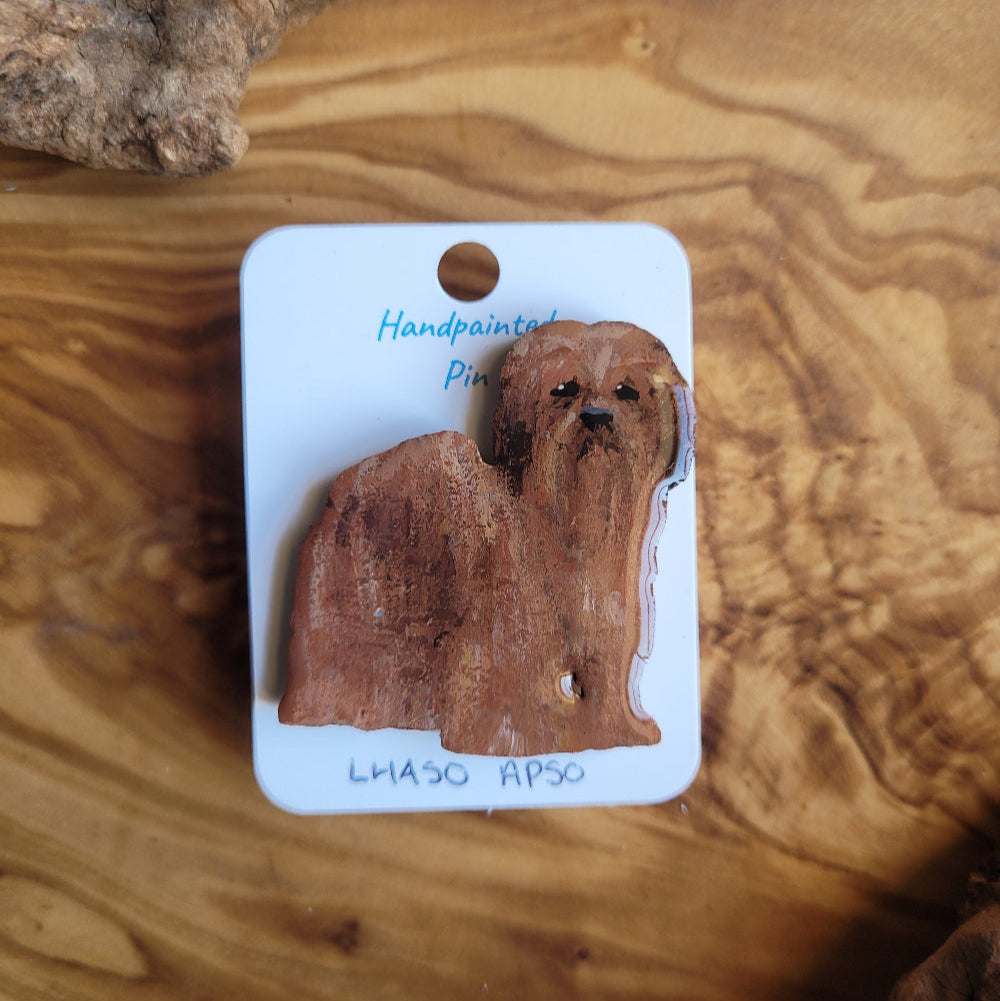 Handpainted wooden lhaso apso dog pin on a white card with 'Handpainted pin' text, placed on a wooden surface.
