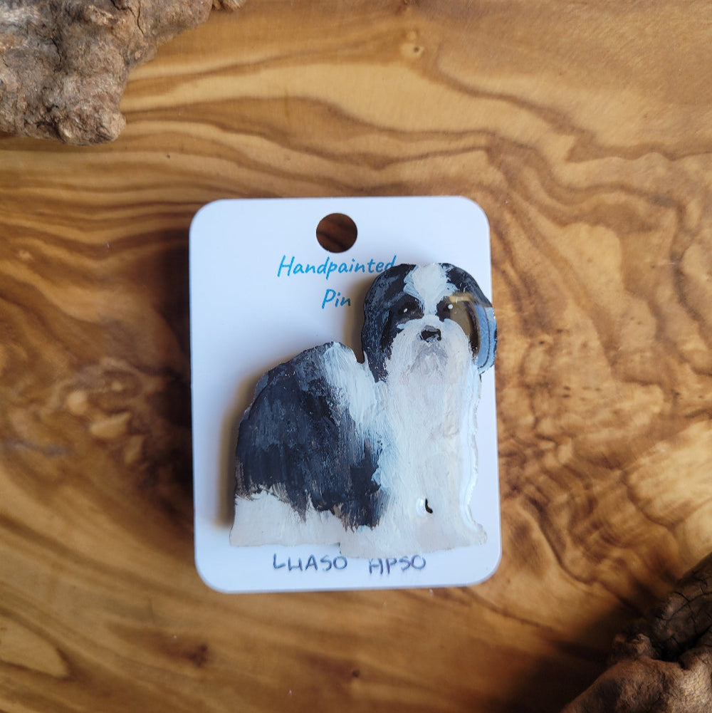Handpainted pin of a lhaso apso dog on a wooden surface