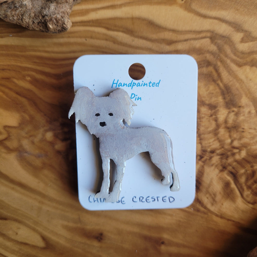 Handpainted chinese crested dog pin displayed on a wooden surface