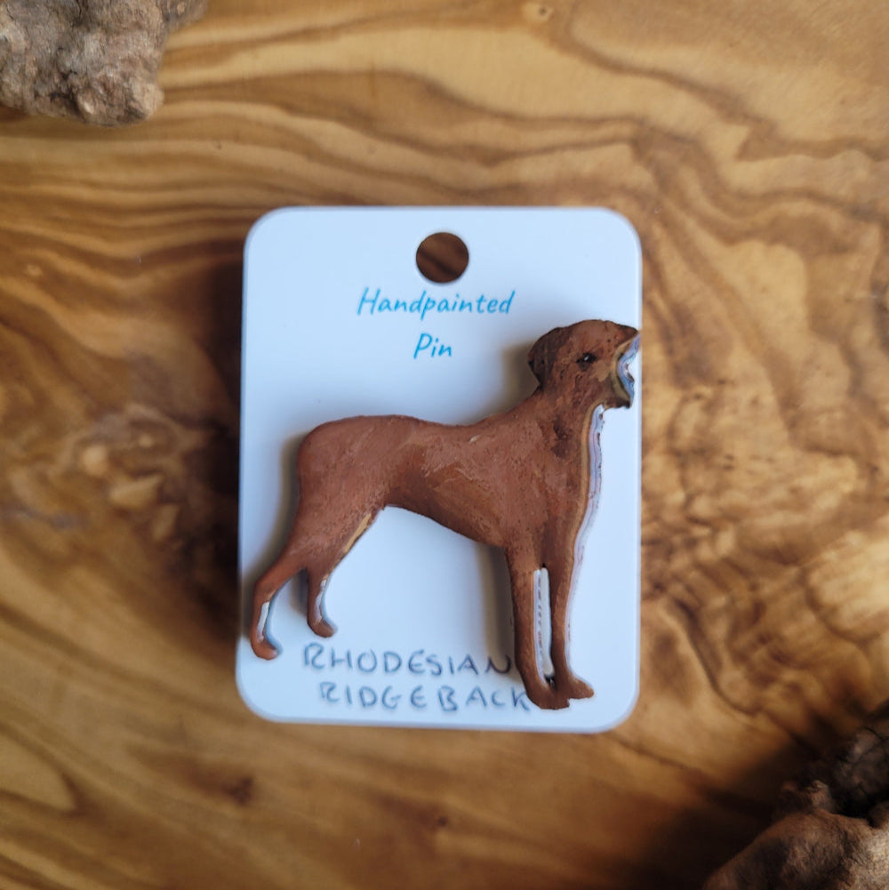 Handpainted pin of a Rhodesian Ridgeback on a wooden surface
