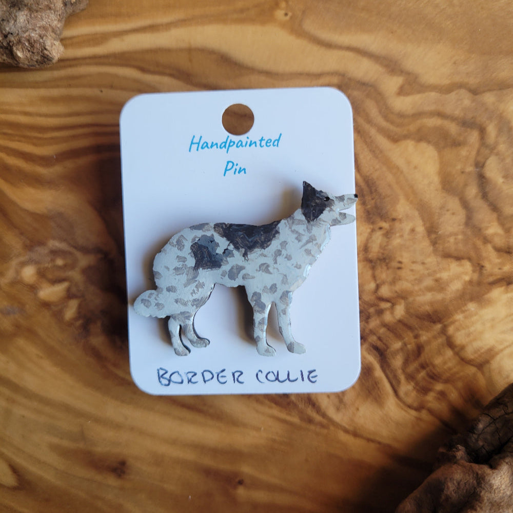Handpainted Border Collie pin on a wooden surface