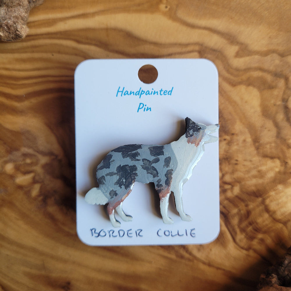 Handpainted Merle Border Collie pin on a wooden surface
