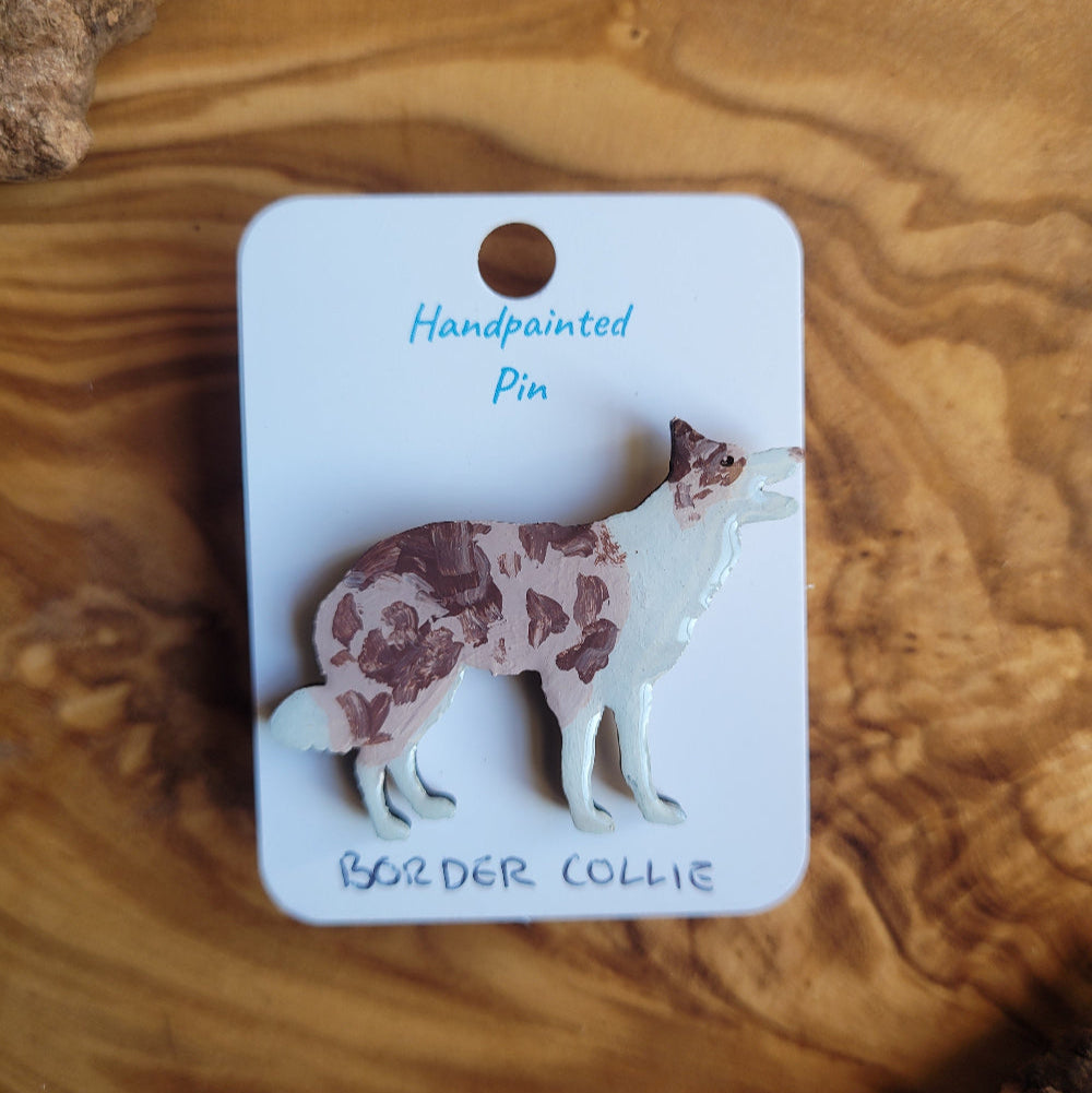 Handpainted Merle Border Collie pin on a wooden surface