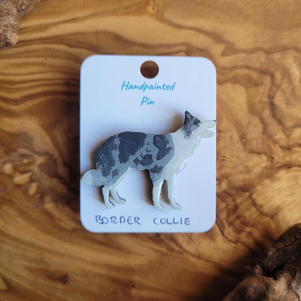 Handpainted Merle Border Collie pin on a wooden surface