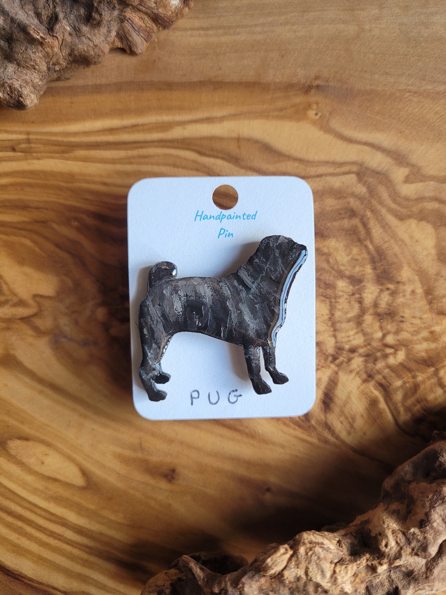 Hand-painted wooden pin badge of a brindle coloured Pug