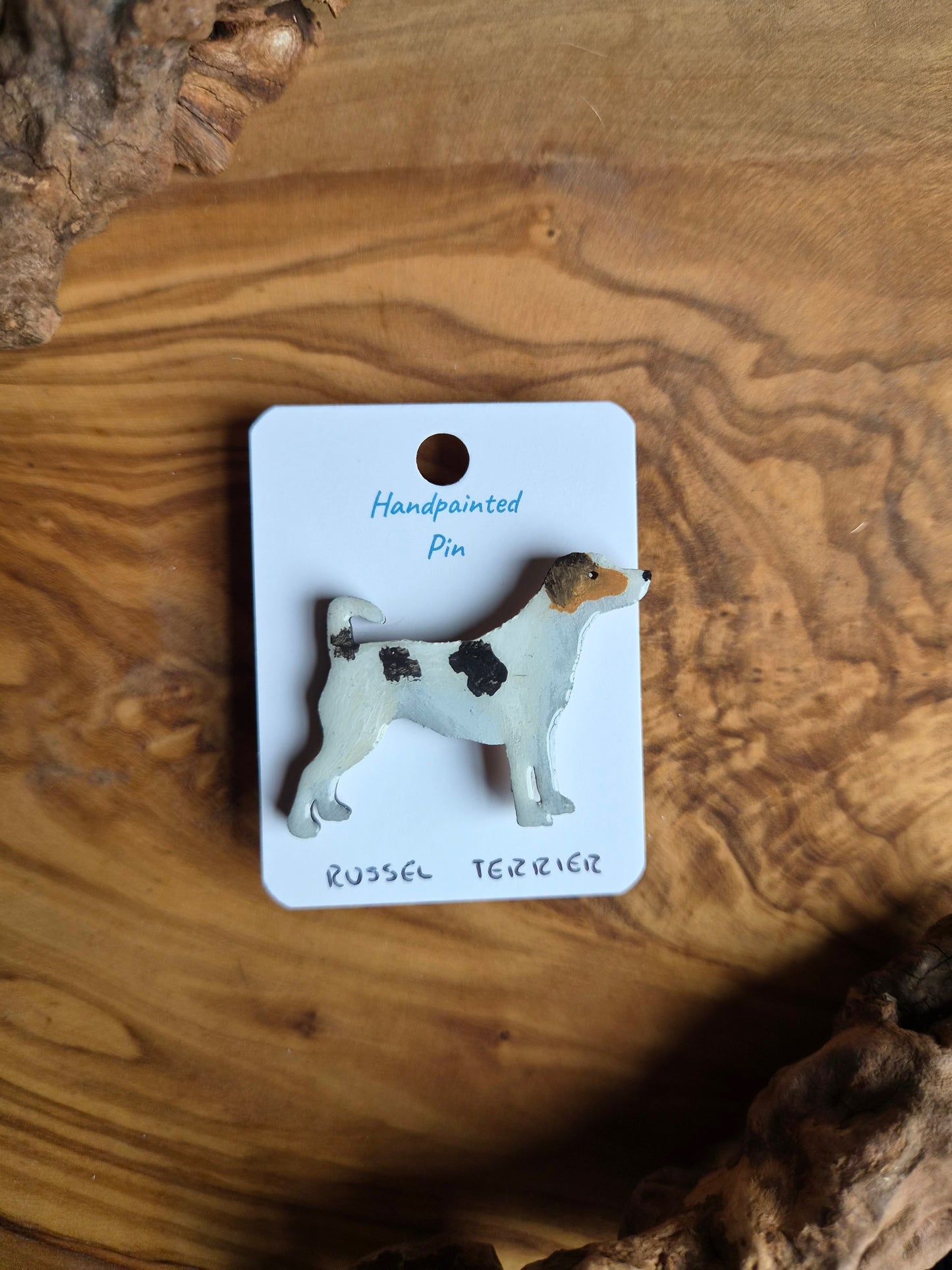 tricoloured, hand-painted wooden pin badge of a Russel Terrier dog