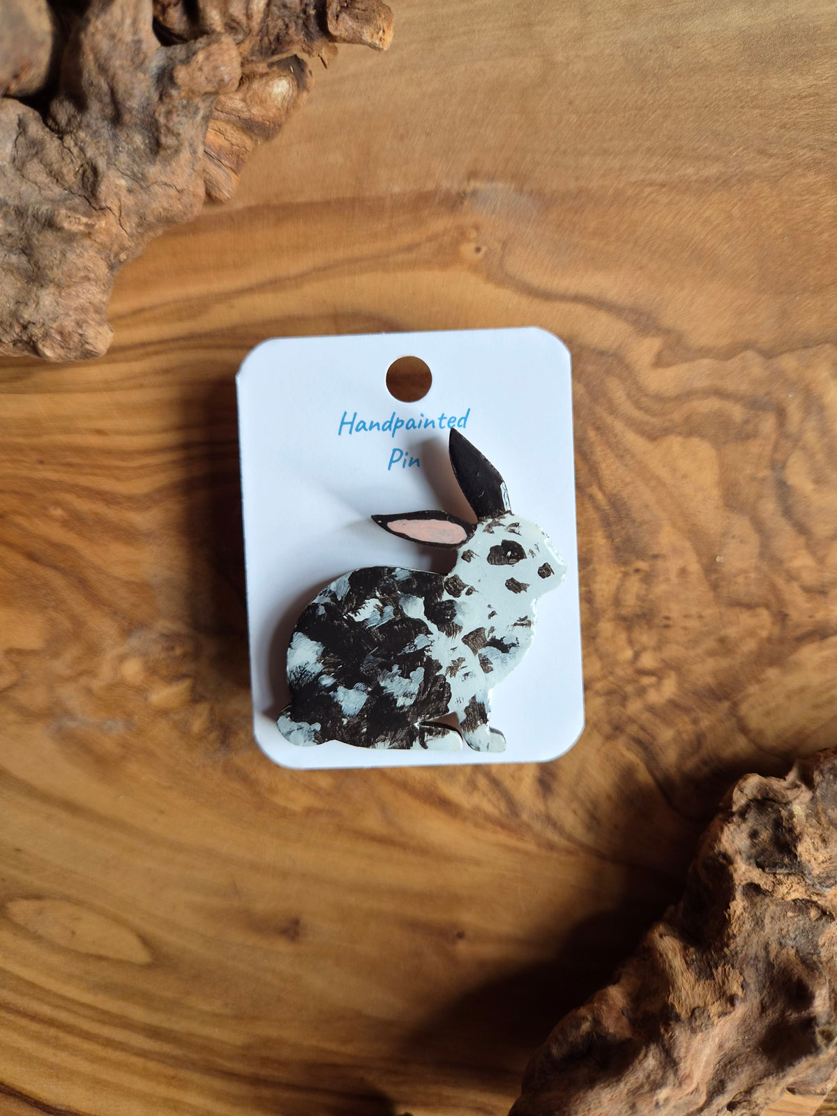 Hand-painted rabbit shaped wooden pin badge. black and white speckled colour