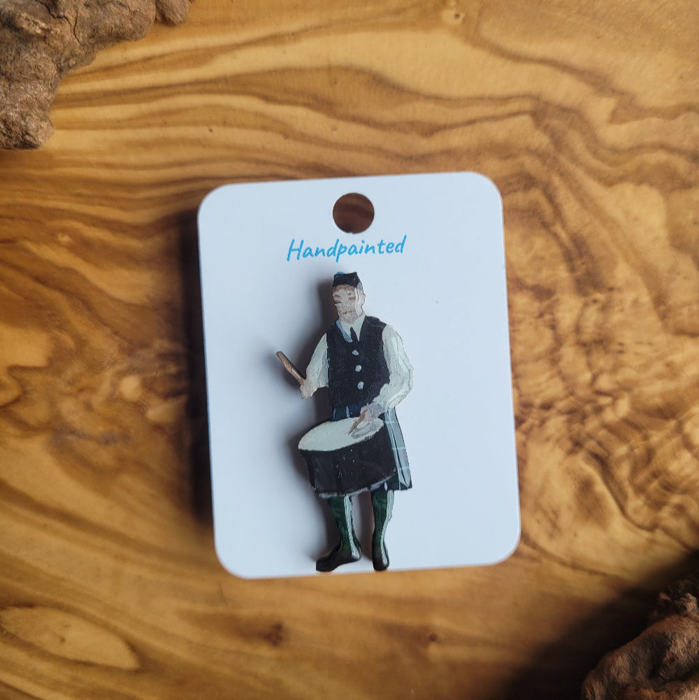 Pin of Scottish Highland Drummer on a card with 'Handmade' text, placed on a wooden surface
