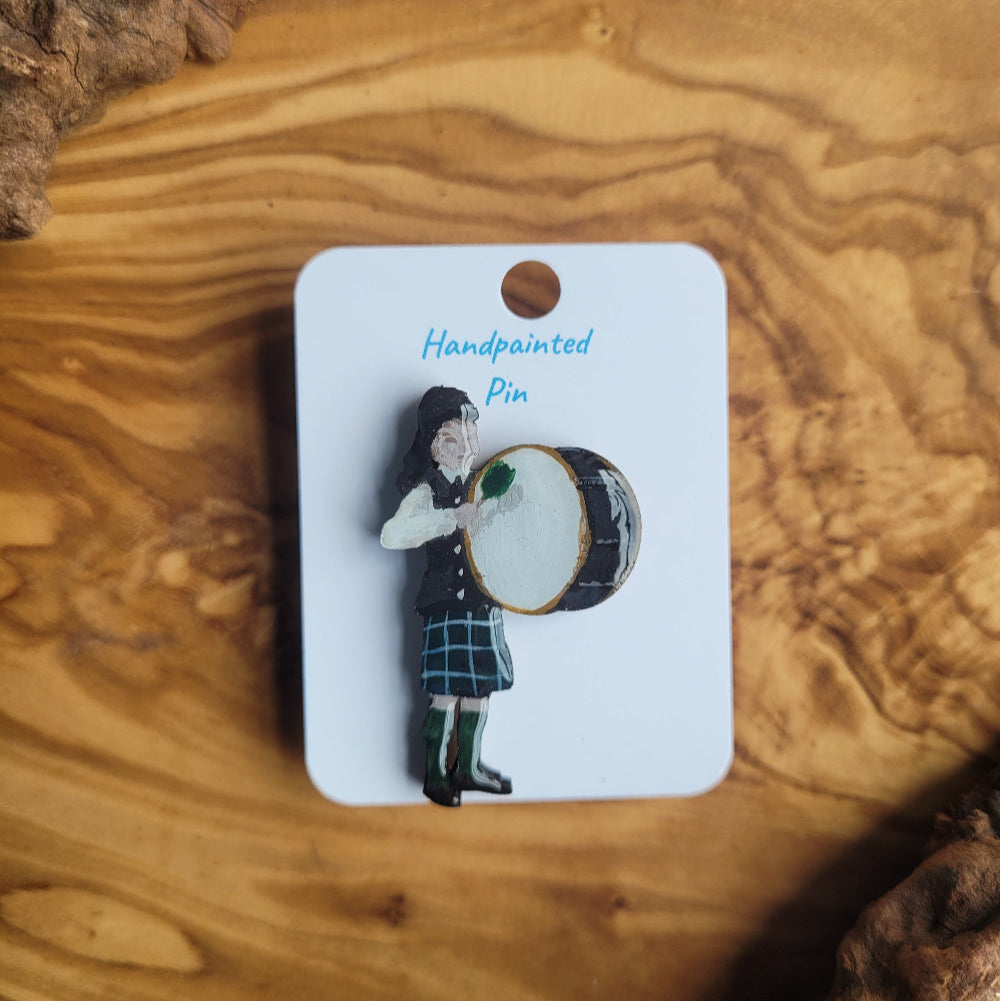 Handpainted pin of a Scottish Highland Drummer on a card with a wooden background