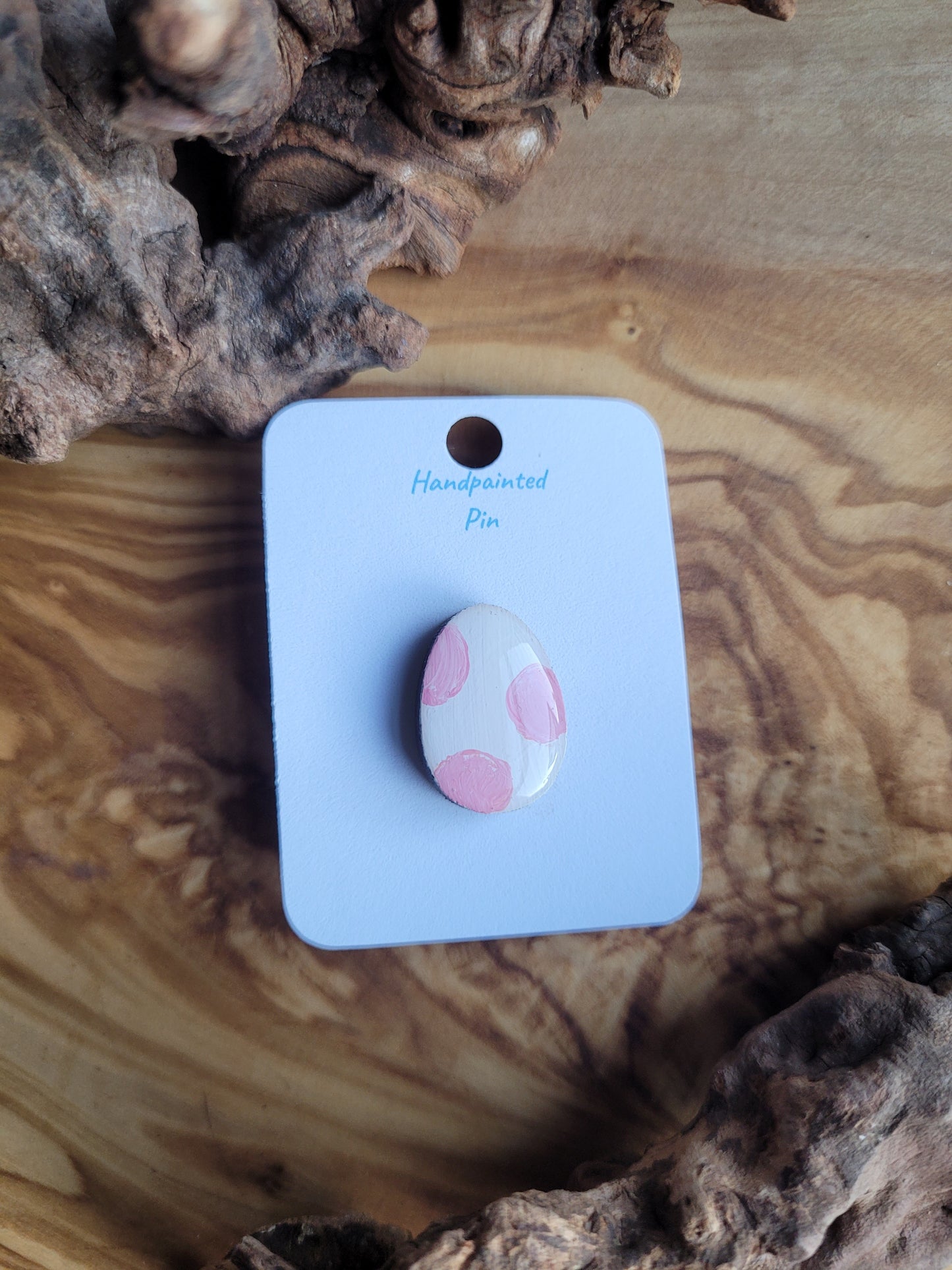 Hand-painted wooden Easter Egg shaped pin badge with pink patches on a white background