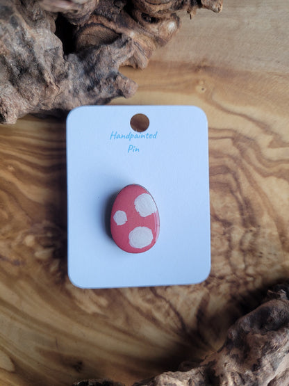 Hand-painted wooden Easter Egg shaped pin badge with white circles on a pink background