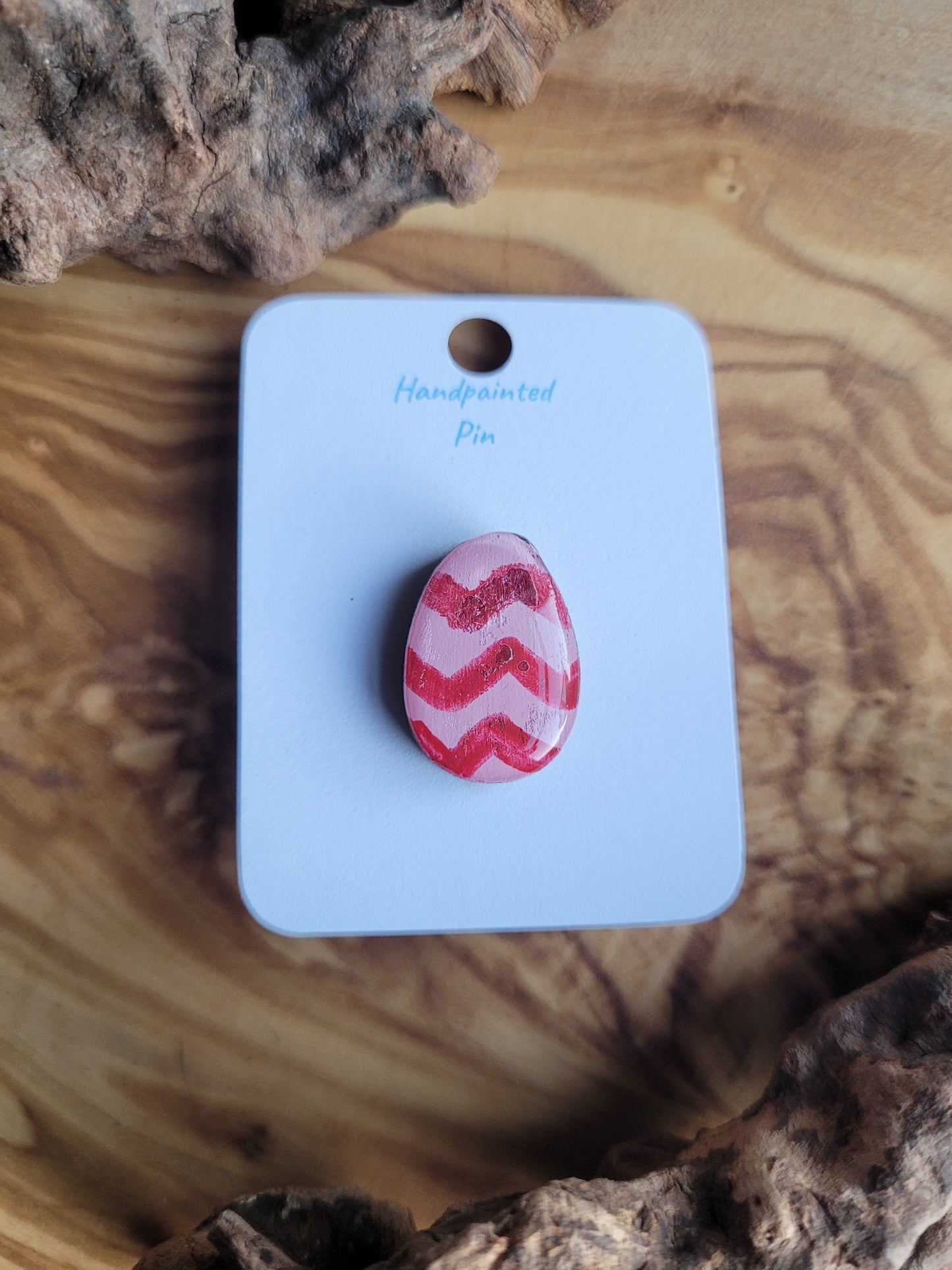 Hand-painted wooden Easter Egg shaped pin badge with pink zigzags over a lighter pink background