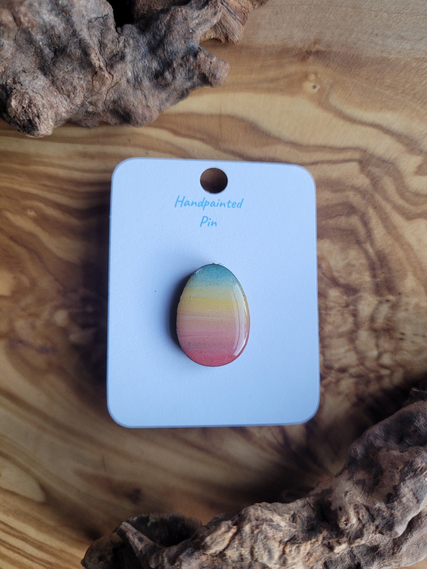 Hand-painted wooden Easter Egg shaped pin badge with a sunset gradient of colours