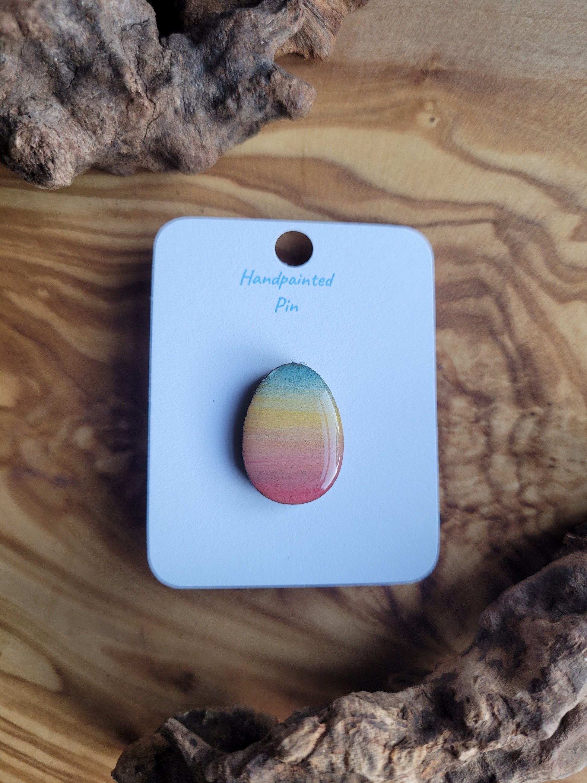 Hand-painted wooden Easter Egg shaped pin badge with a sunset gradient of colours