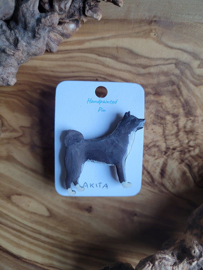 hand-painted wooden pin badge of a black Akita dog