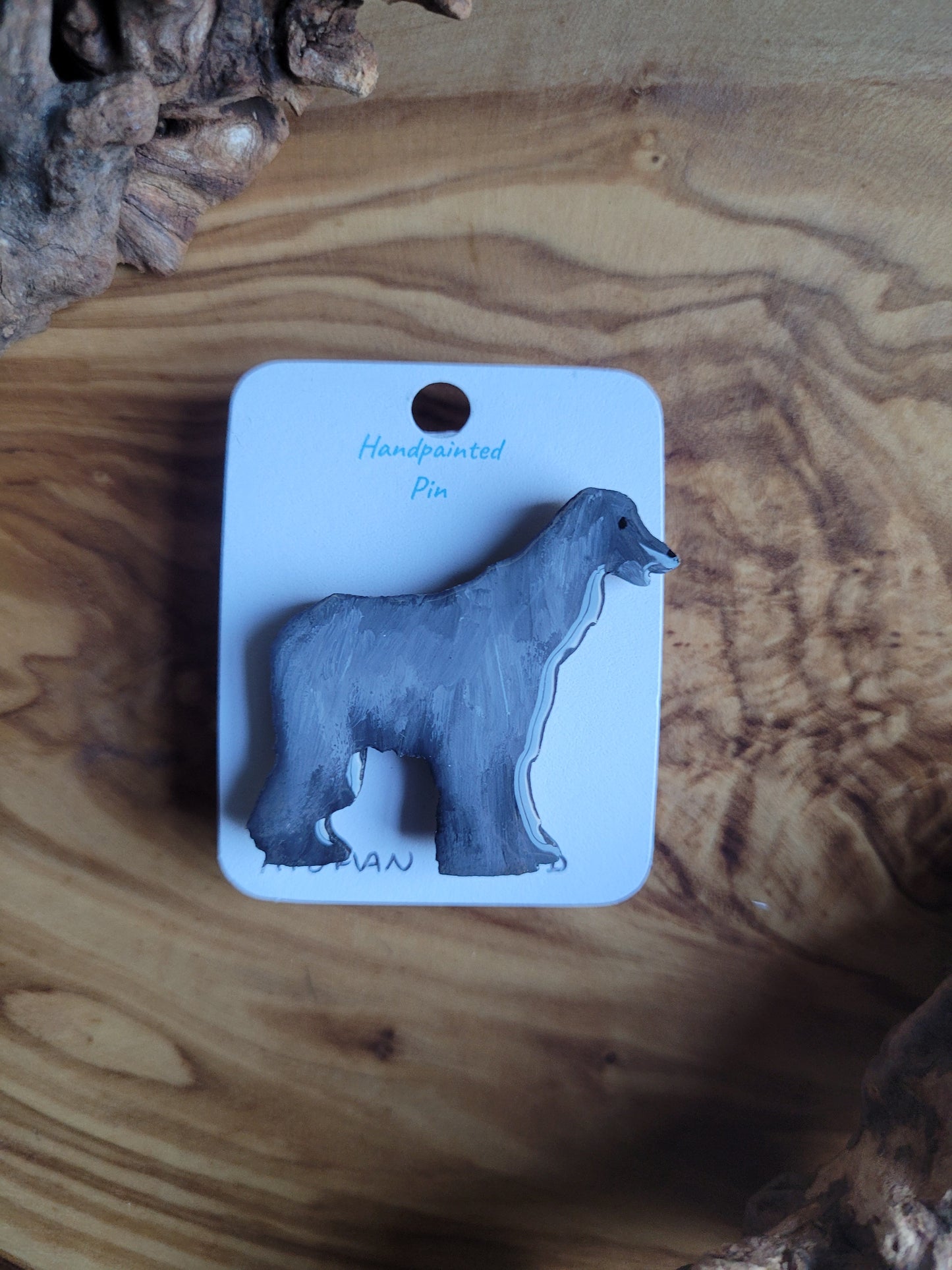 Silver-grey hand-painted Afghan Hound dog pin on a wooden base