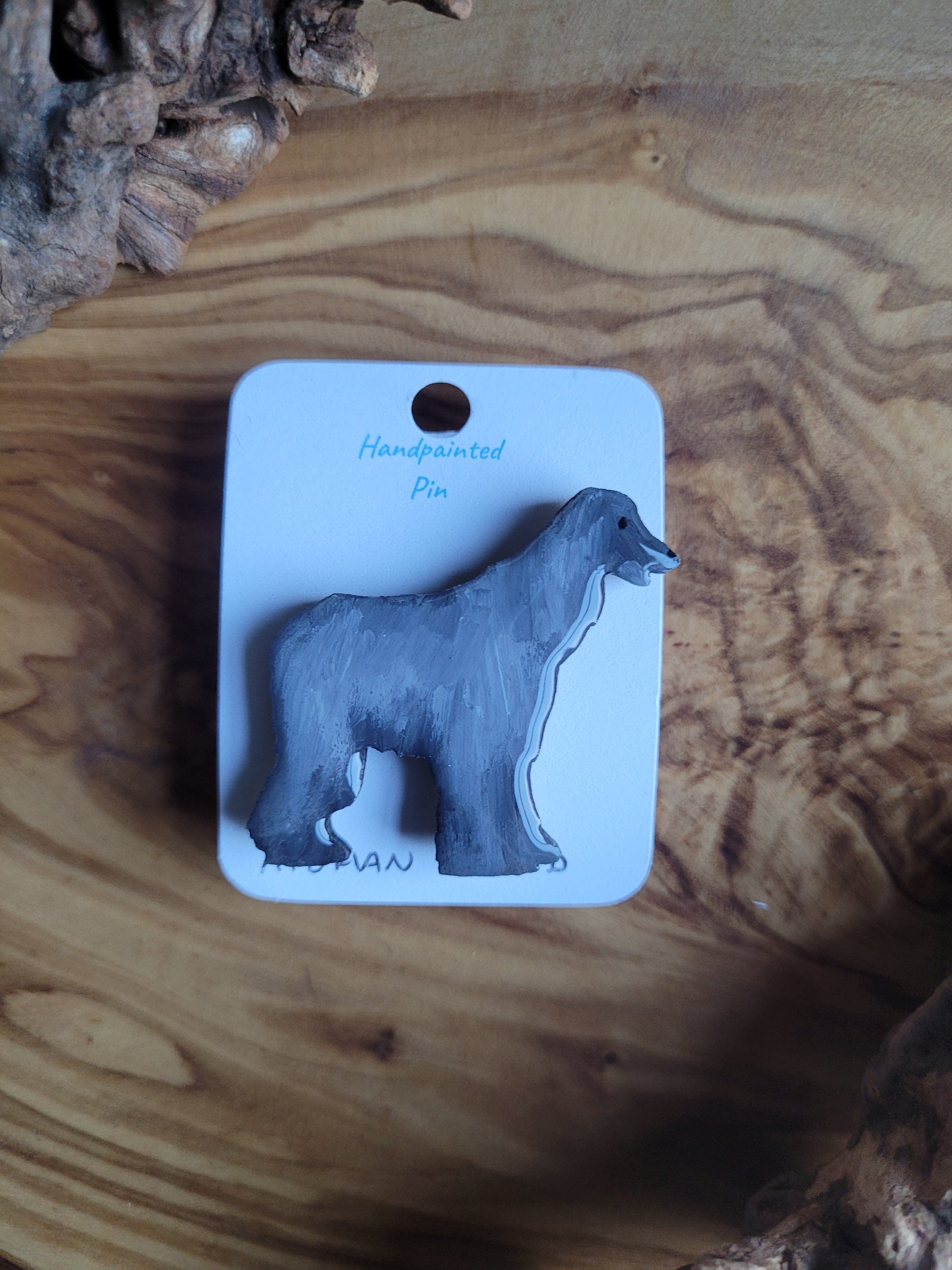 Silver-grey hand-painted Afghan Hound dog pin on a wooden base