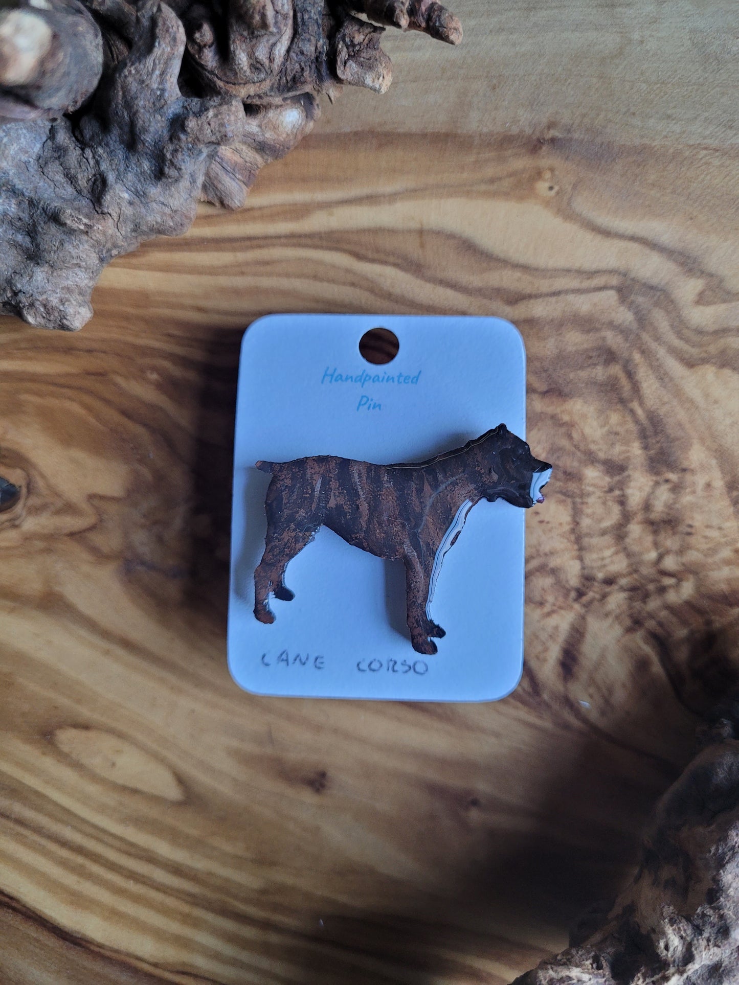Hand-painted wooden pin badge of a brindle coloured Cane Corso dog.