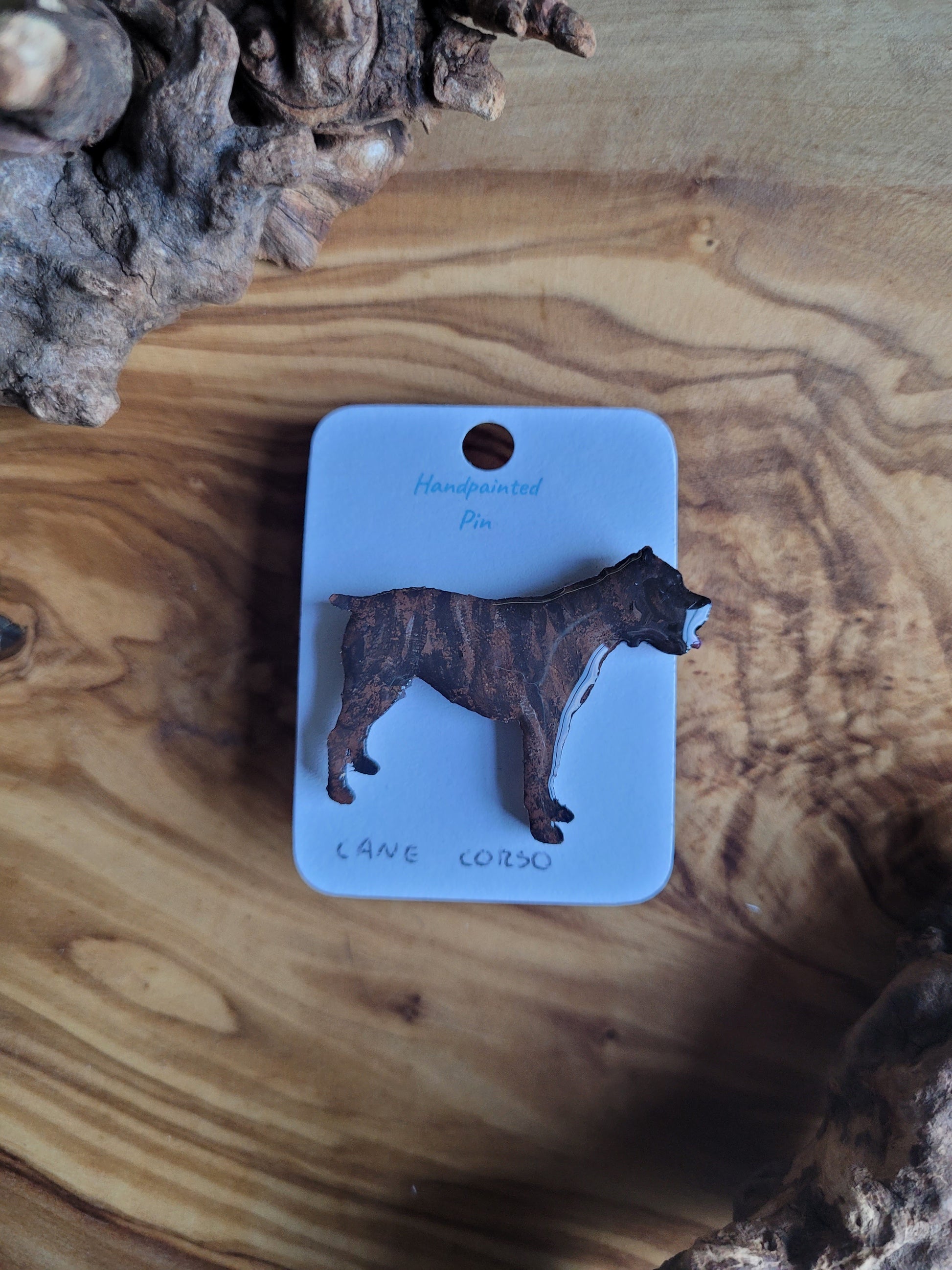 Hand-painted wooden pin badge of a brindle coloured Cane Corso dog.