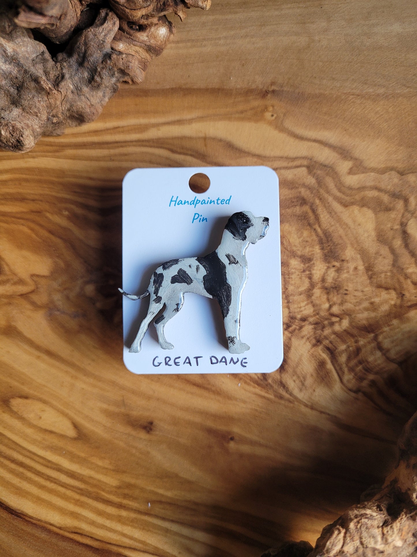 Hand-painted wooden pin badge of a white and black Great Dane