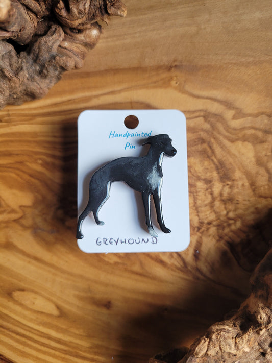 Hand-painted Greyhound pin badge, painted onto wood. Black with white chest.