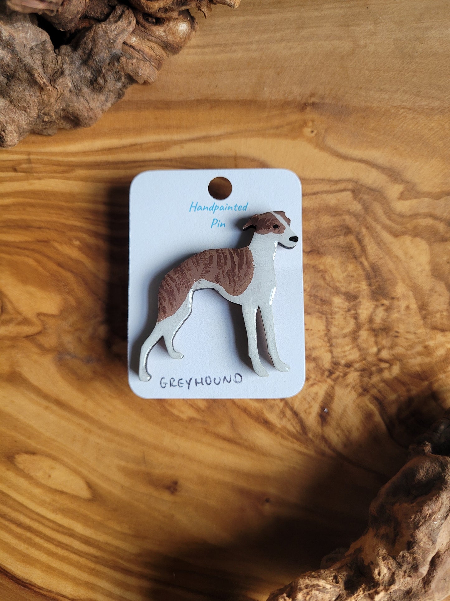 Hand-painted Greyhound pin badge, painted onto wood. Brindle and white