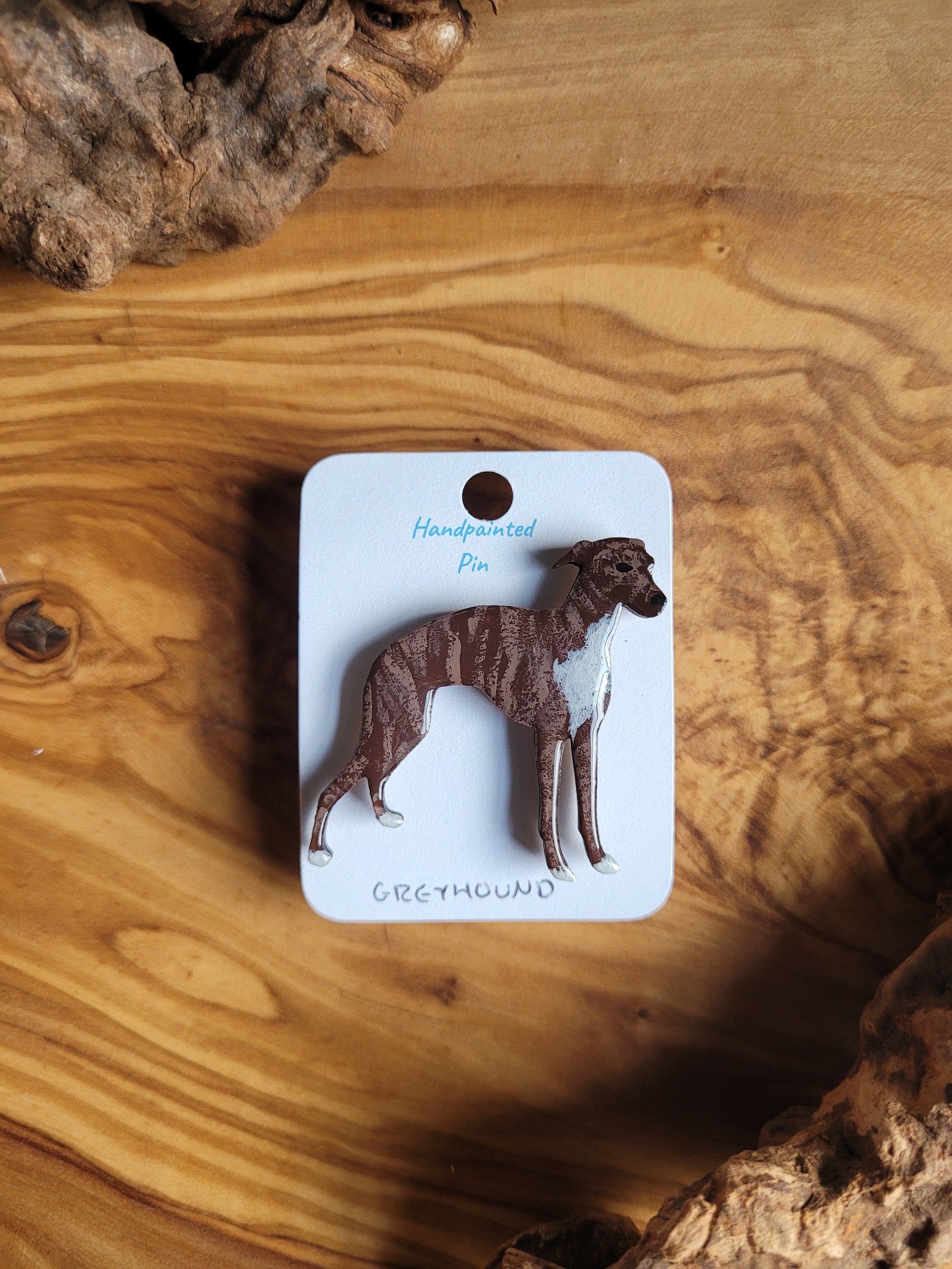 Hand-painted Greyhound pin badge, painted onto wood. Brindle with white chest