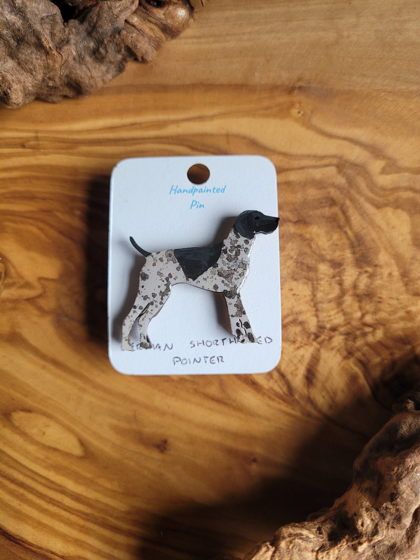 Hand-painted wooden dog pin of a German Shorthaired Pointer, white speckled with a black patch over the head and one on the back