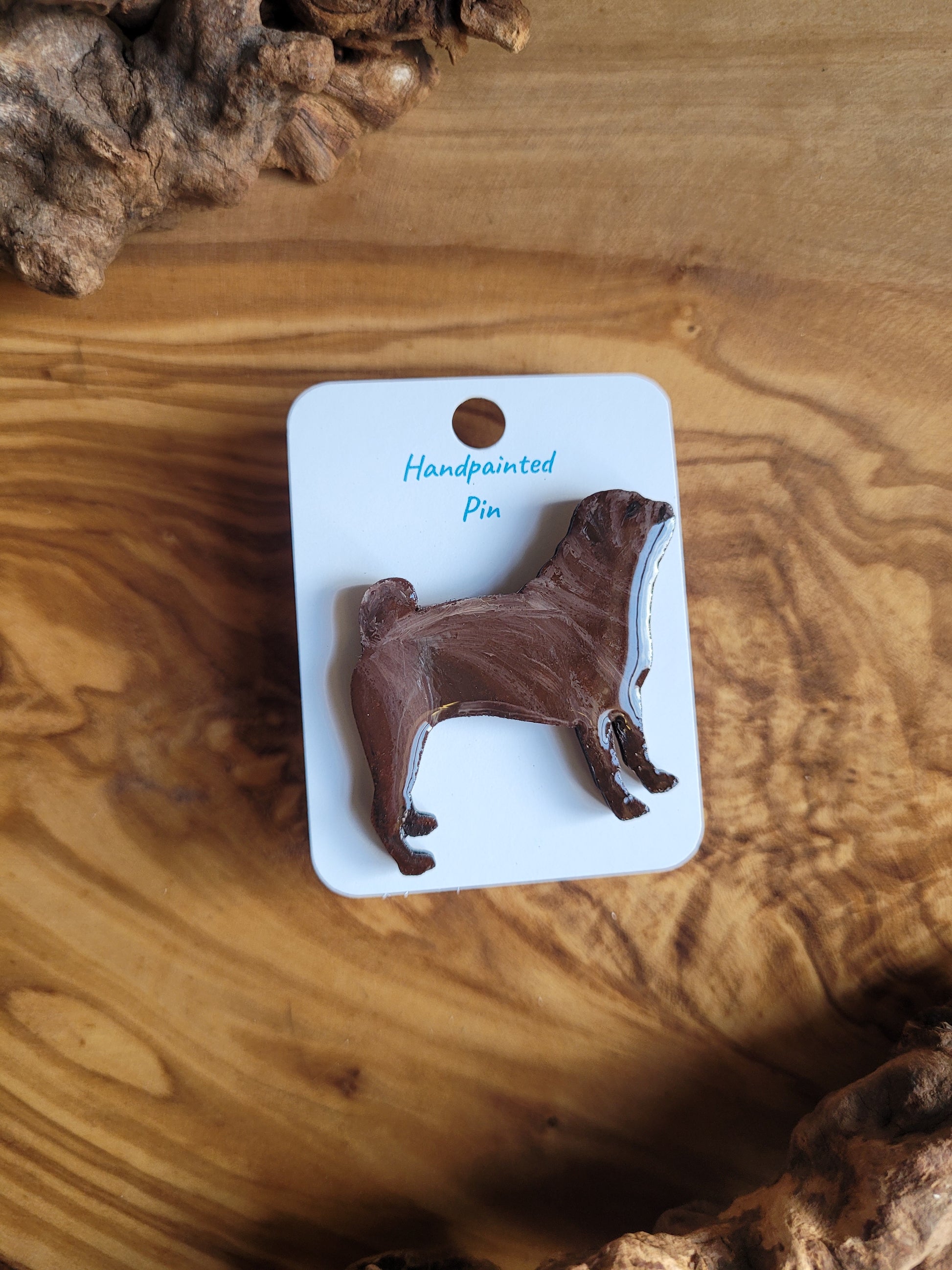 Hand-painted wooden pin badge of a chocolate coloured Pug