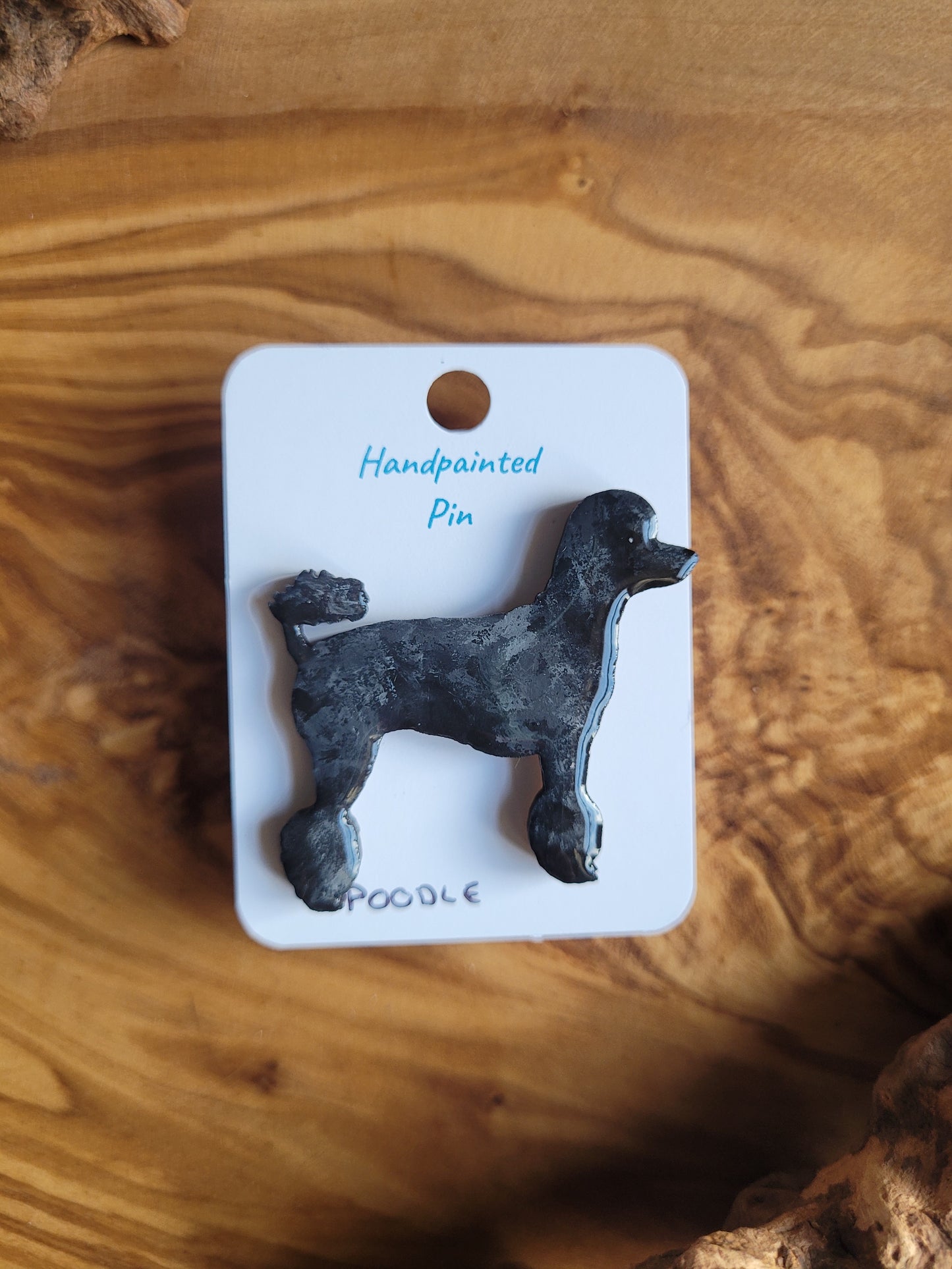 Black hand-painted wooden pin badge of a poodle dog