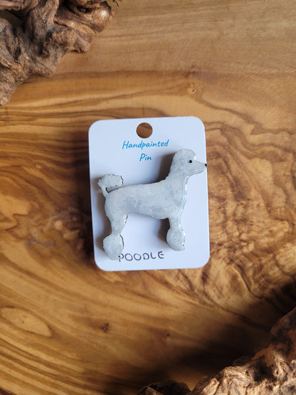 White hand-painted wooden pin badge of a poodle dog