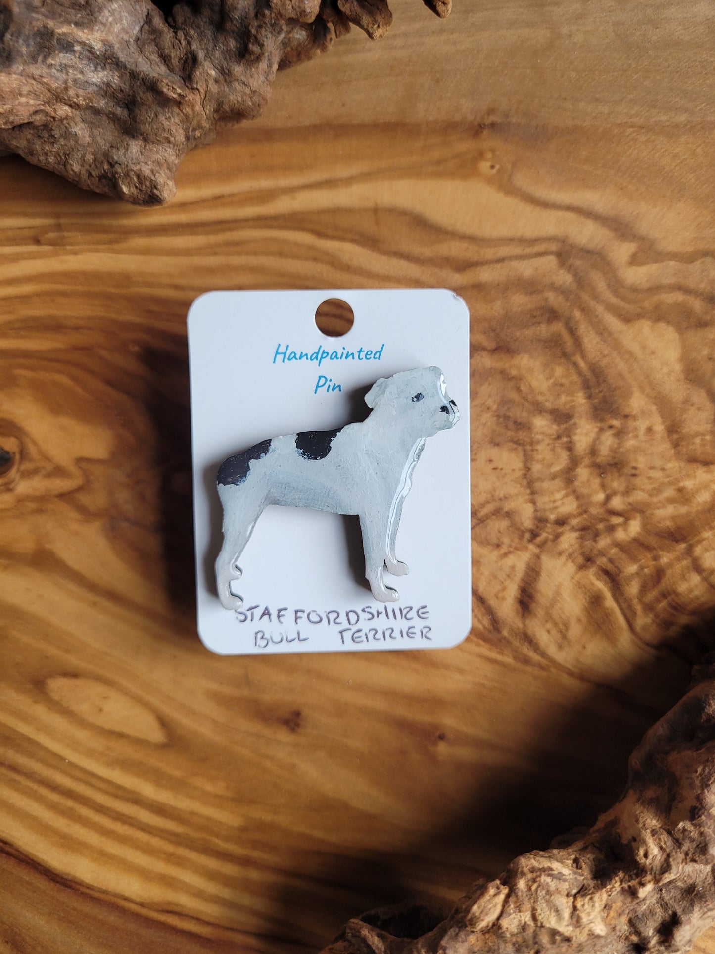 Hand-painted staffordshire bull terrier dog pin badge, painted onto wood. White with two black patched on the back colour