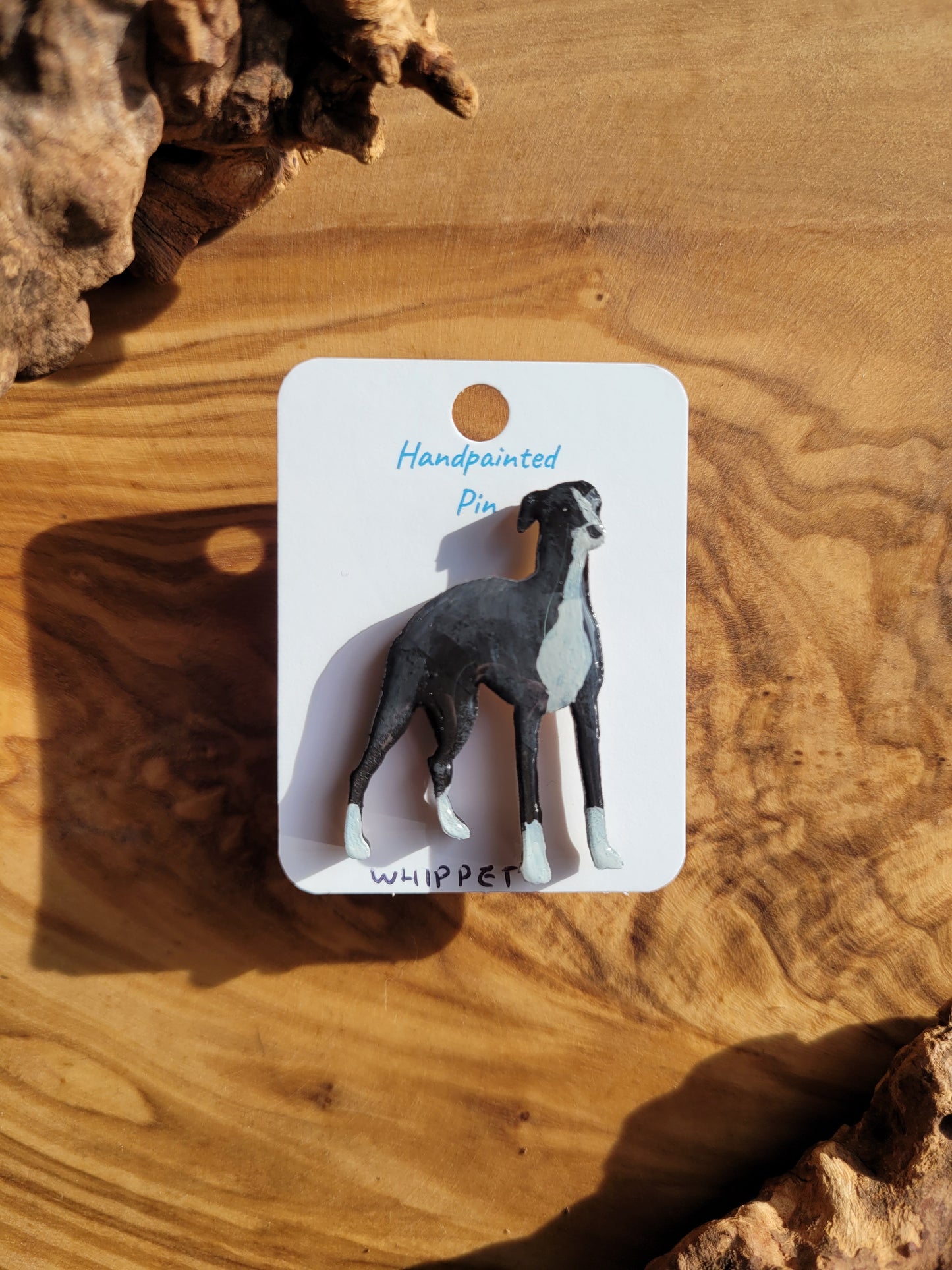 Hand-painted wooden dog pin badge of the Whippet hound. Black with white
