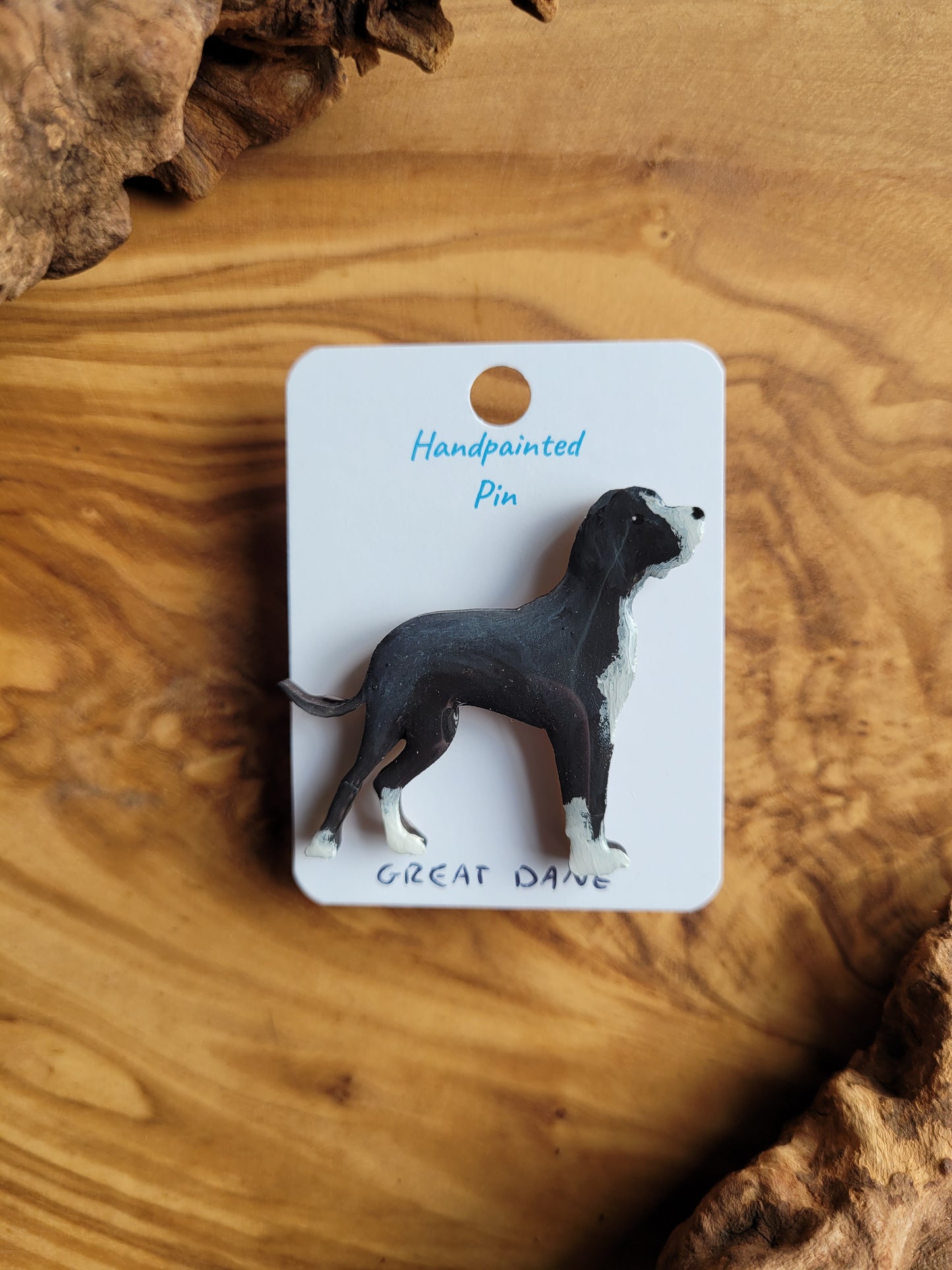 Hand-painted wooden pin badge of a black with white face, chest and paws Great Dane