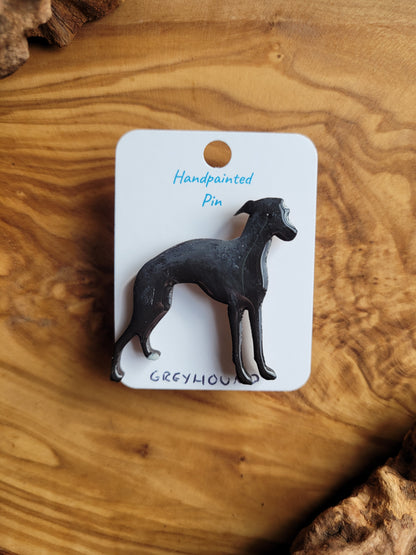Hand-painted Greyhound pin badge, painted onto wood. Black with 1 white paw