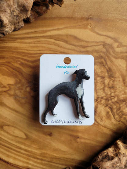 Hand-painted Greyhound pin badge, painted onto wood. Black with white chest and paws