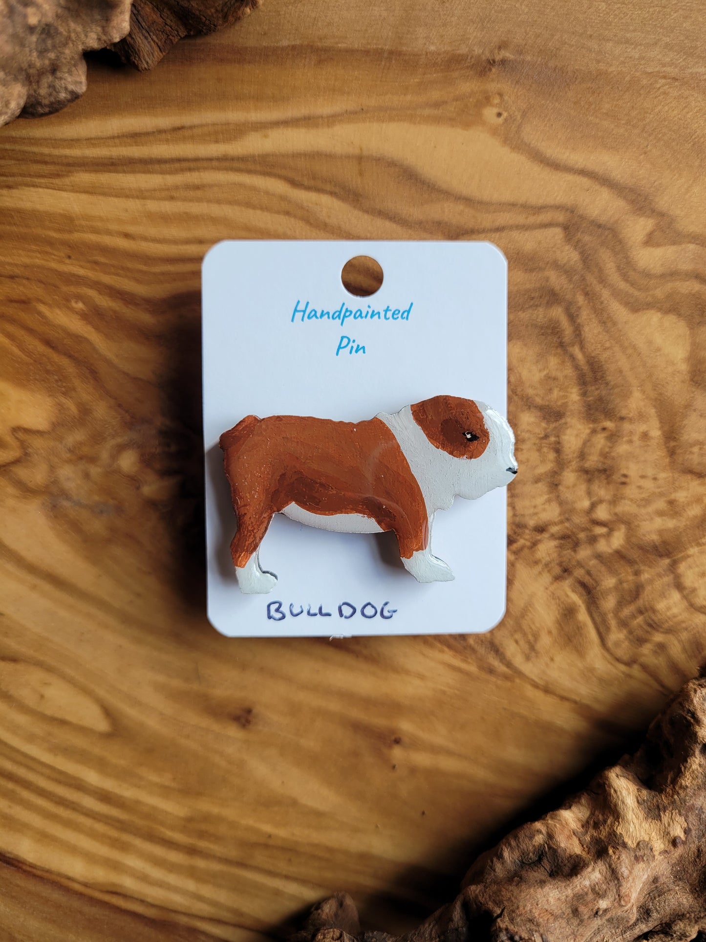 Hand-painted wooden dog pin of a red and white bulldog