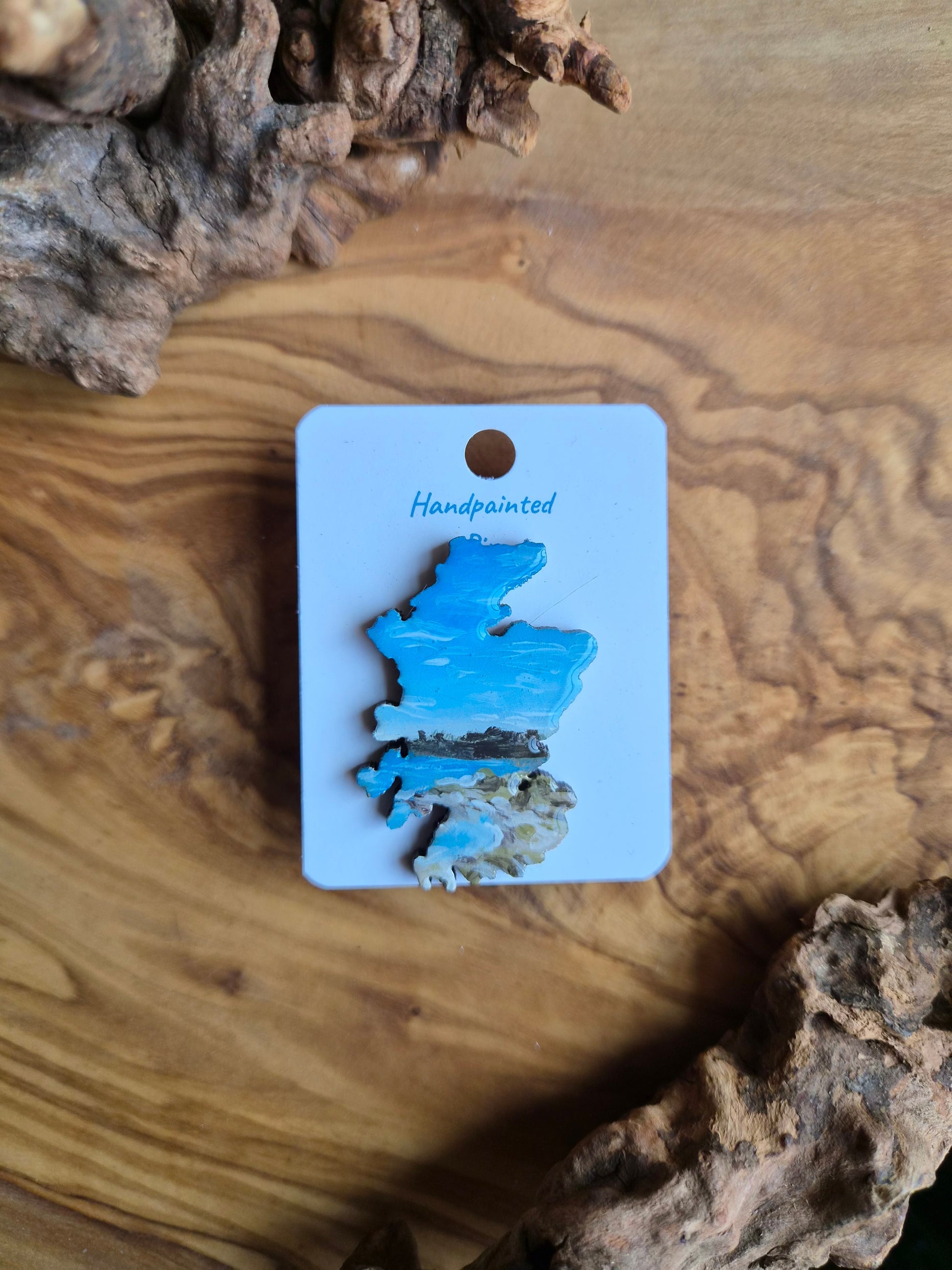 Hand-painted Scotland shaped wooden pin badge with a scottish landscape of findhorn bay painted on