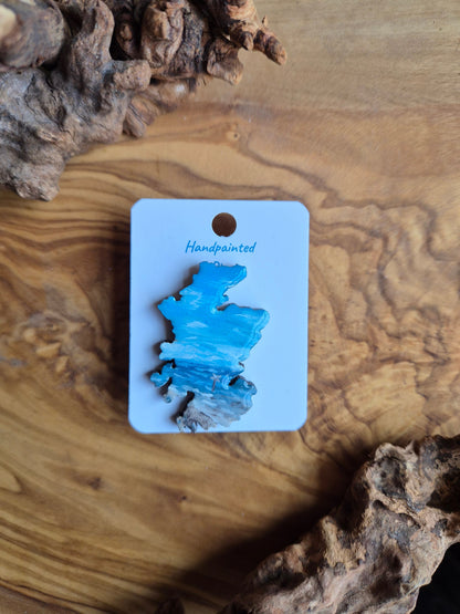 Hand-painted Scotland shaped wooden pin badge with a scottish landscape of findhorn beach painted on