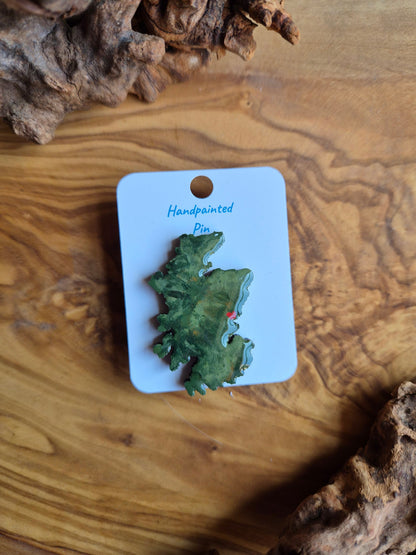 Hand-painted Scotland shaped wooden pin badge with a scottish terrain painted on with a location marker on Dundee