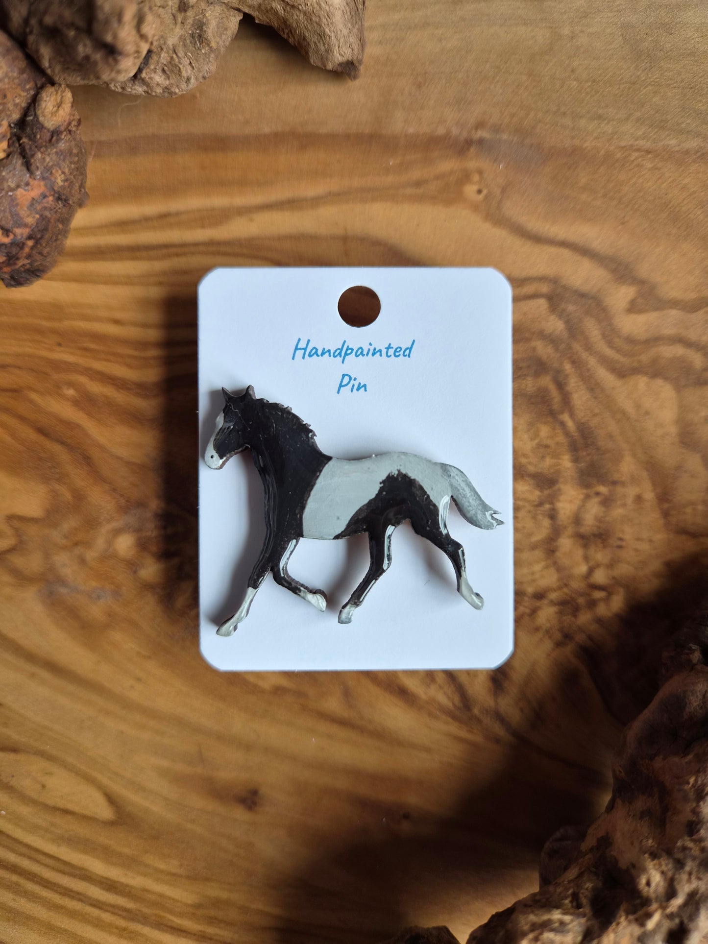 Hand-painted horse shaped wooden pin badge.  Black and white piebald colour