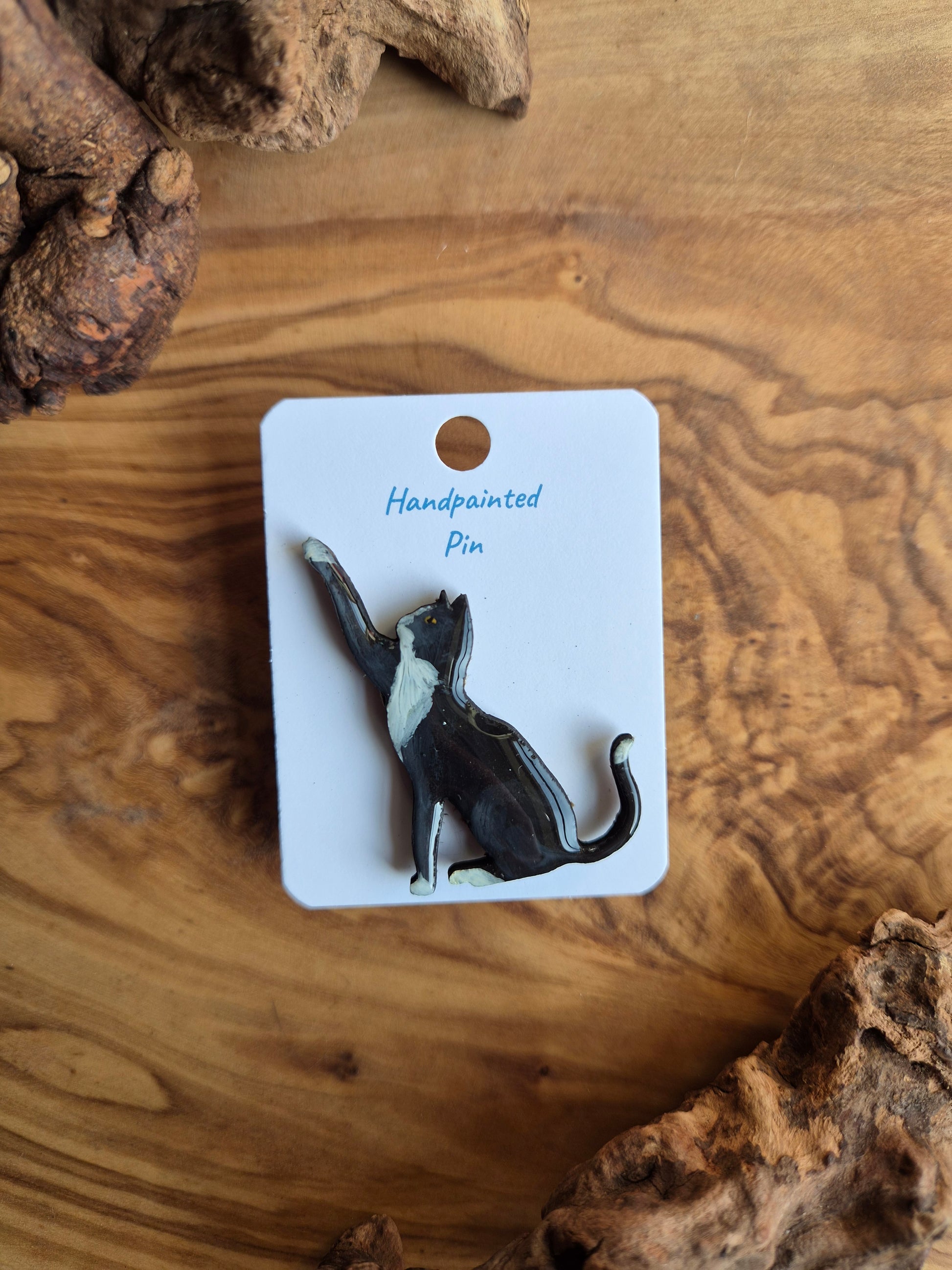 Hand-painted wooden pin badge of a black and white tuxedo coloured cat