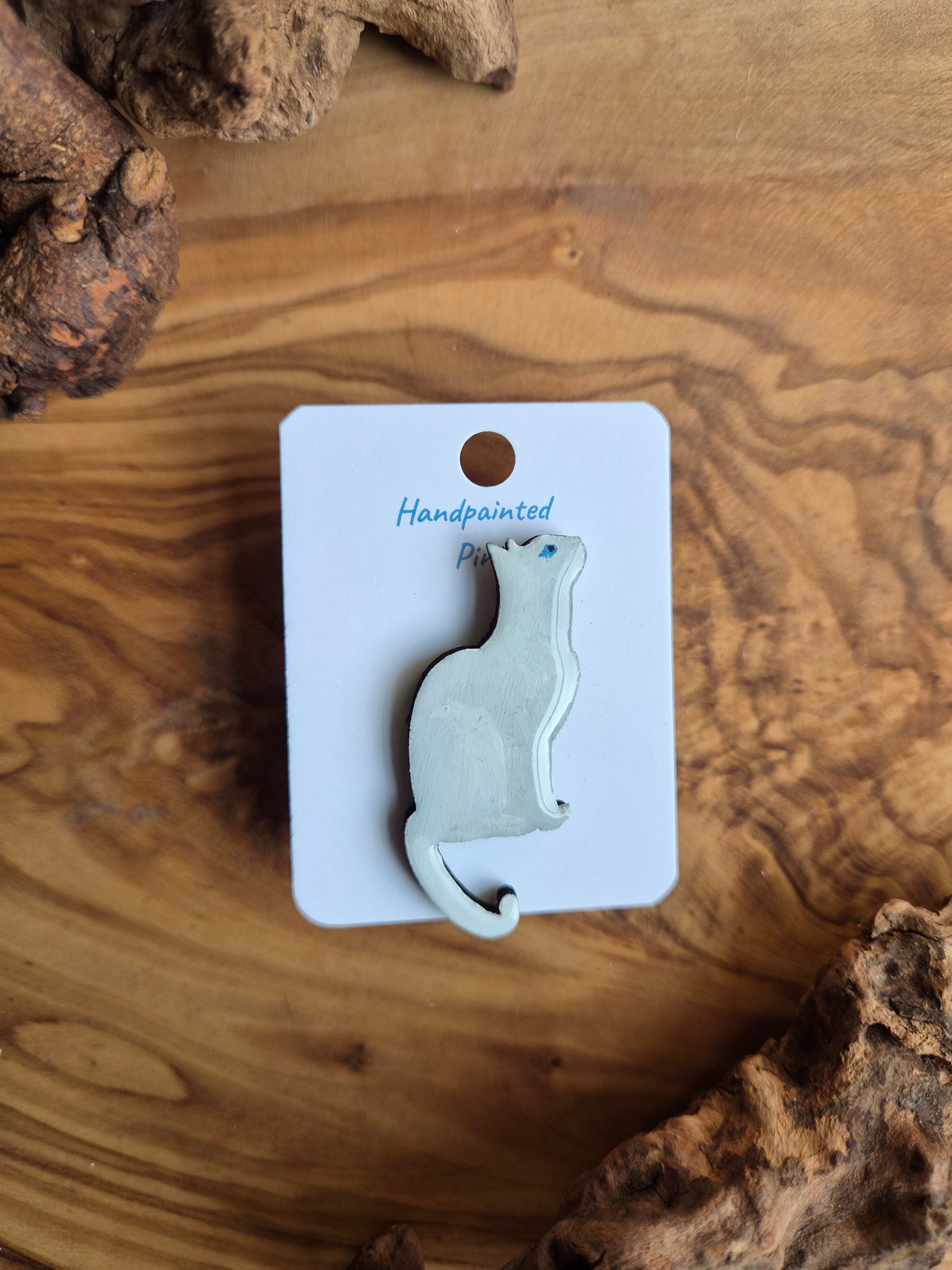 Hand-painted wooden pin badge of a white with blue eyes cat