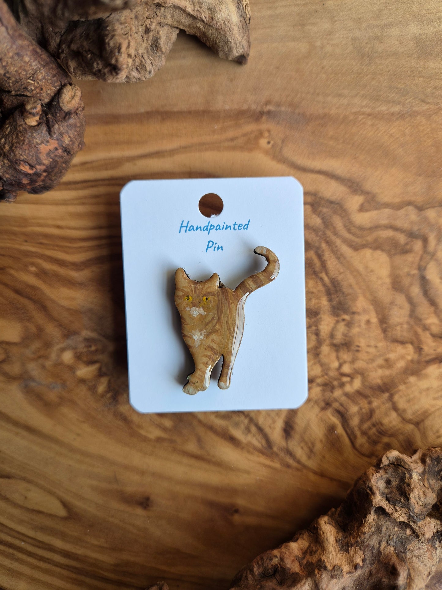 Hand-painted wooden pin badge of a ginger coloured cat with some white