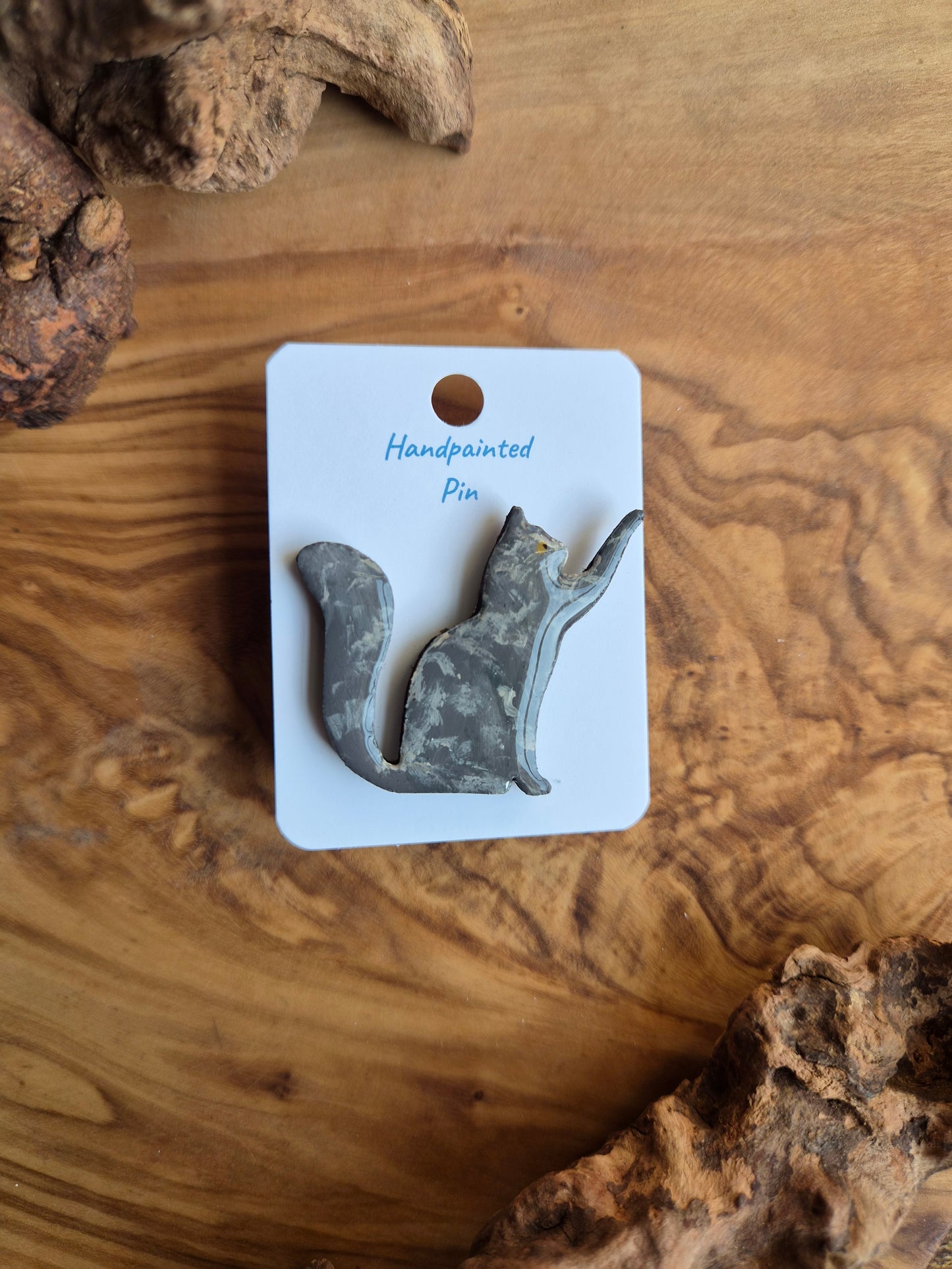 Hand-painted wooden pin badge of a dilute tortoiseshell coloured cat