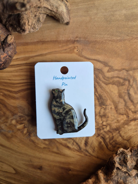 Hand-painted wooden pin badge of a dark tortoiseshell coloured cat