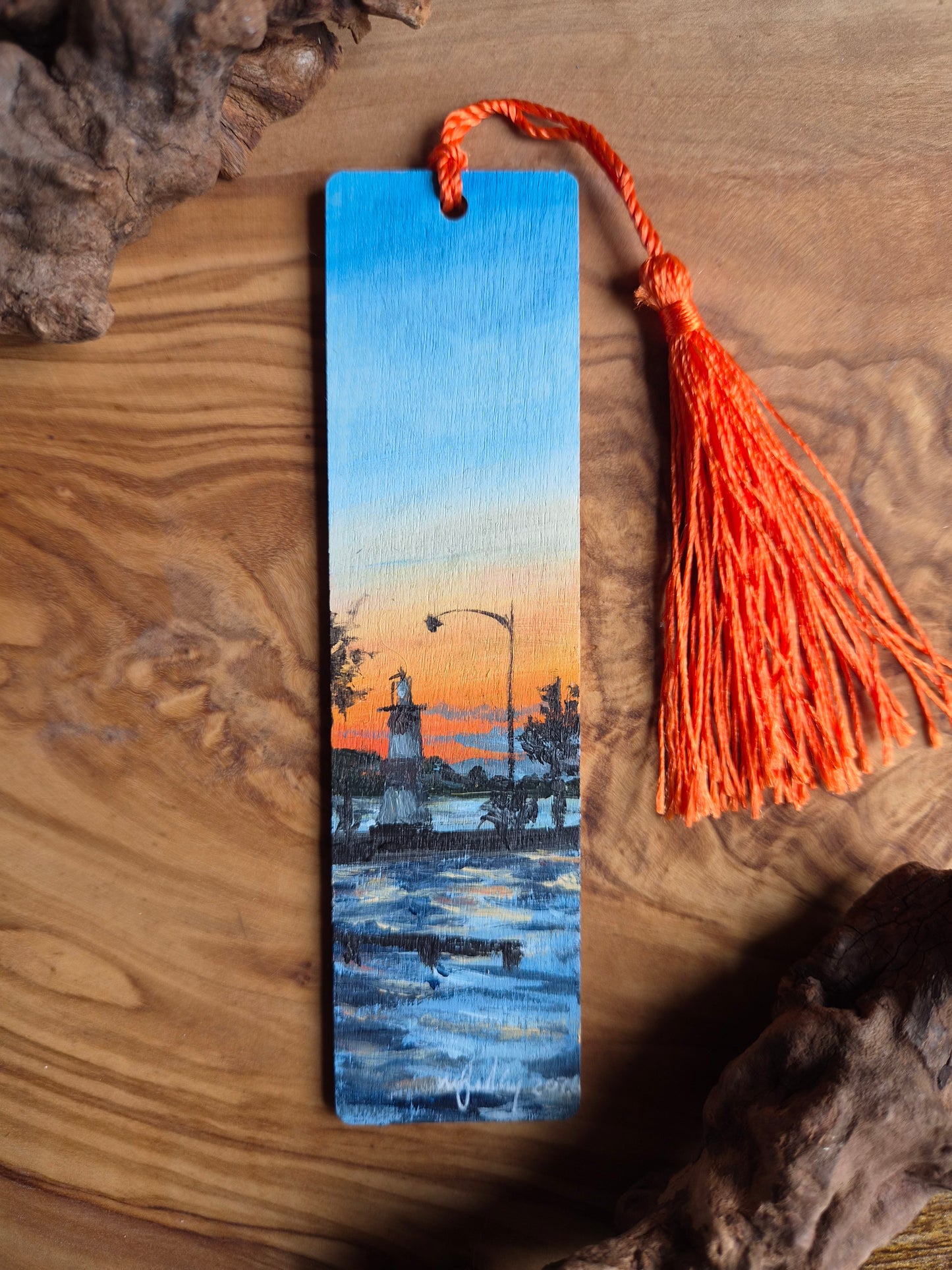 Hand-painted wooden bookmark of a sunset behind the lighthouse in Mount Dora, Florida