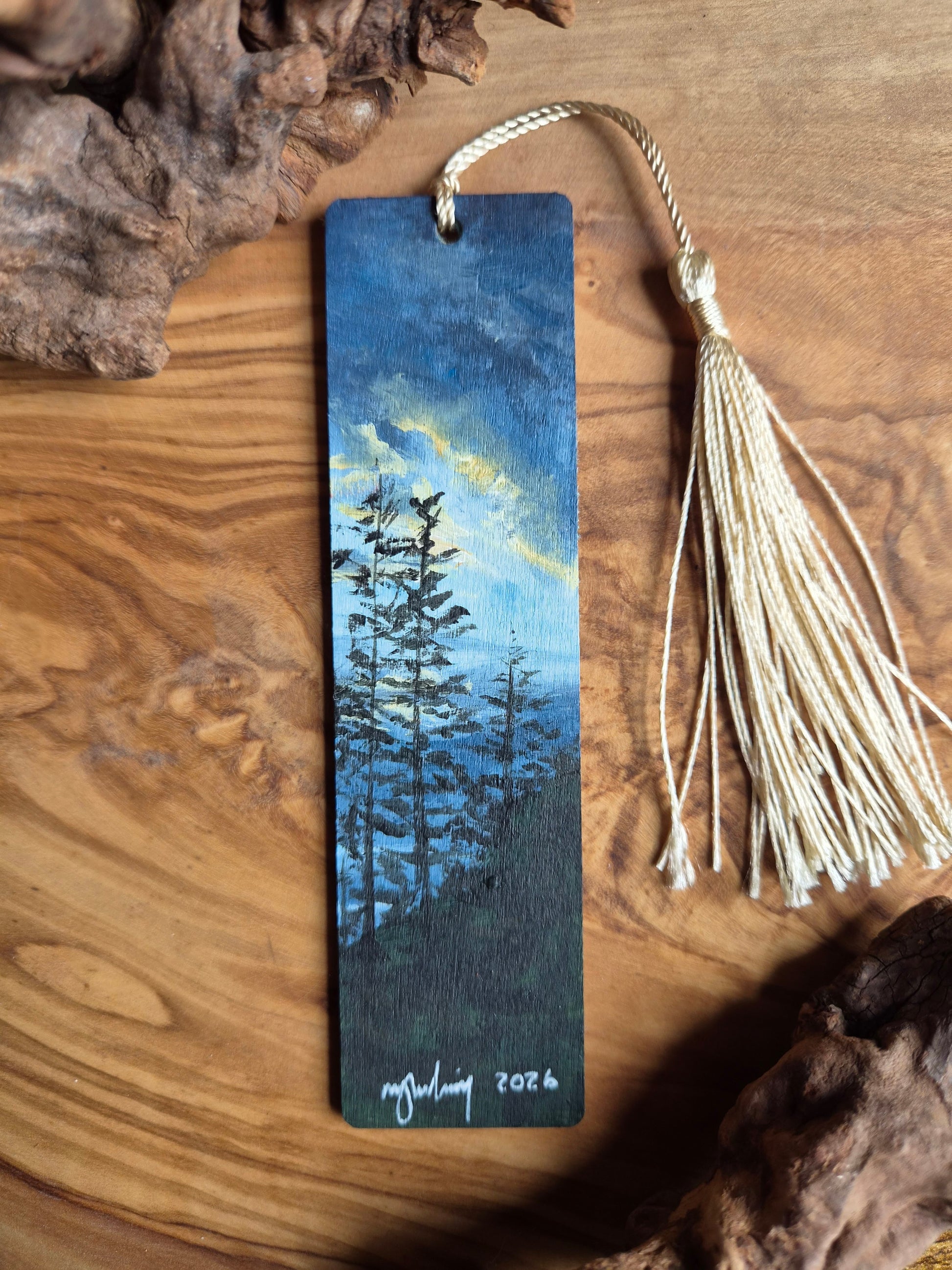 Hand-painted wooden bookmark of tree silhouettes against a evennig sunset