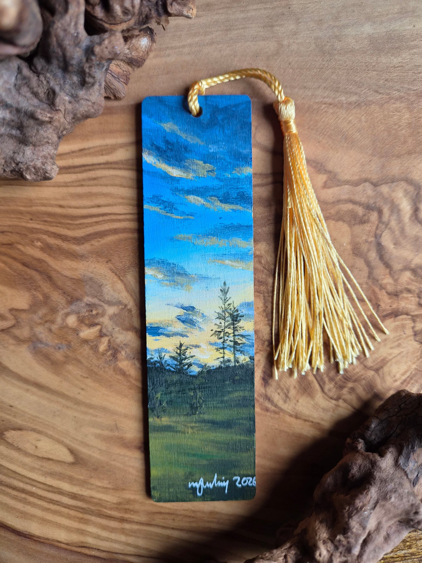 Hand-painted wooden bookmark of a sunset from a grassy field and distant trees