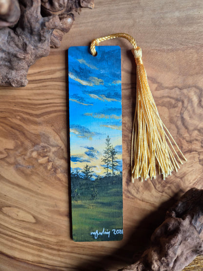 Hand-painted wooden bookmark of a sunset from a grassy field and distant trees